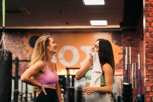 two young women talking in the gym while resting photo