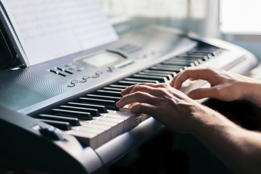 man playing piano with a music sheet photo