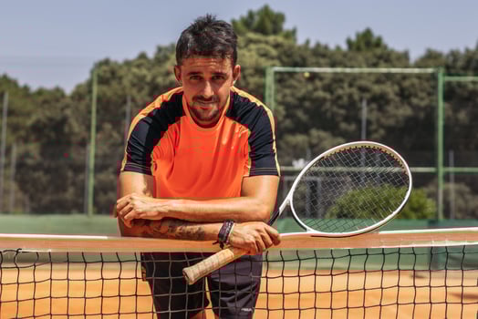 Man in sportswear playing tennis on a dirt tennis court photo