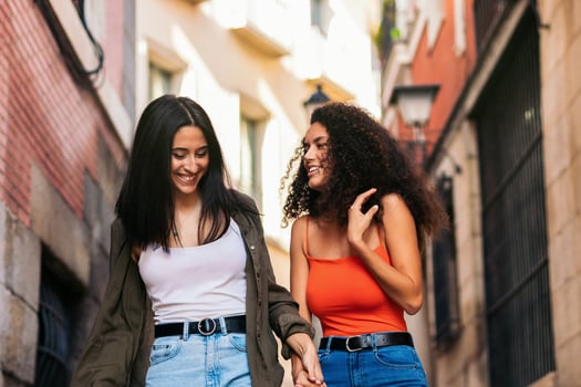 two young women going down street stairs smiling holding her hands photo
