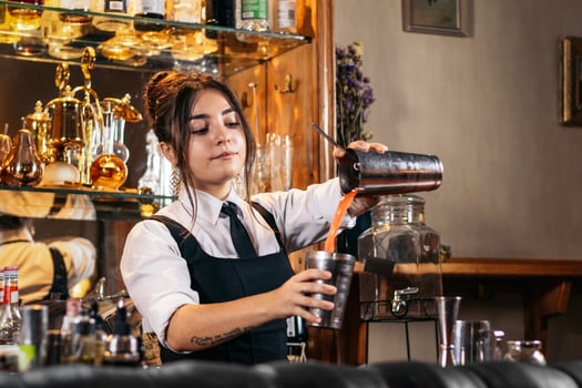 Female bartender preparing a cocktail in a traditional cocktail bar photo