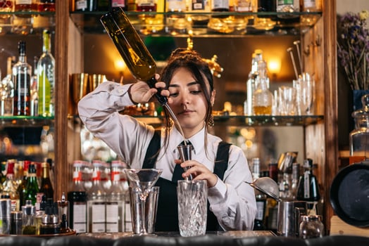 Female bartender preparing a cocktail in a traditional cocktail bar photo