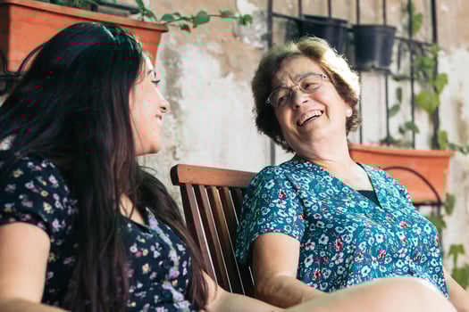 A woman and a woman sitting on a bench photo