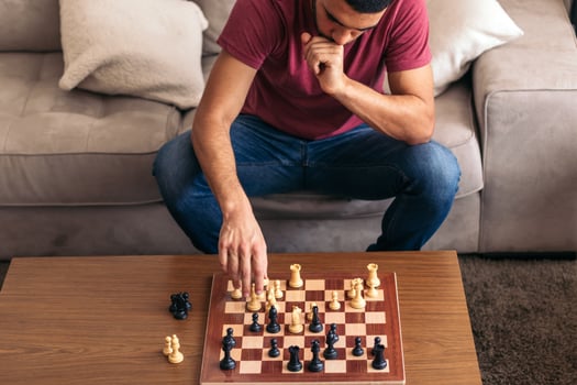 A man sitting on a couch playing chess photo