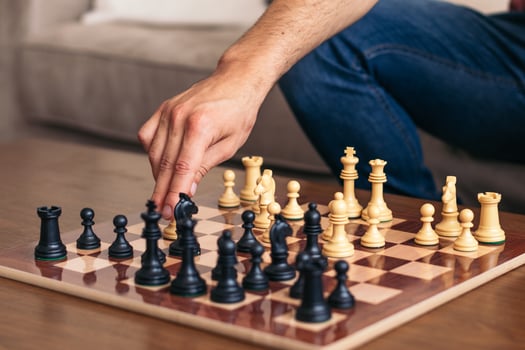 A person is playing chess on a wooden table photo