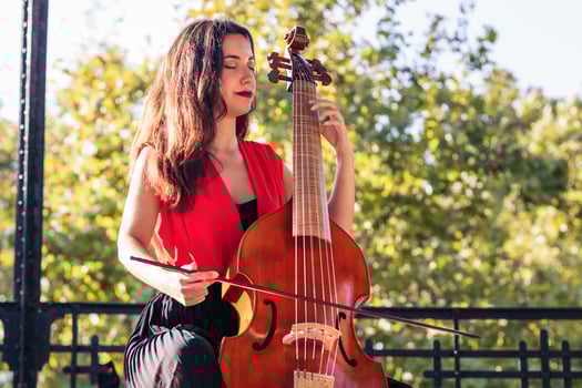 Woman musician playing cello outdoors photo