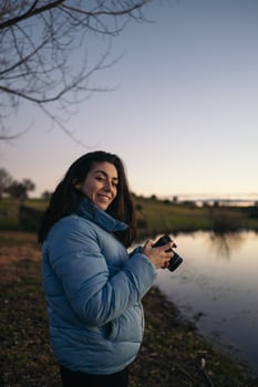 A woman in a blue jacket holding a camera photo