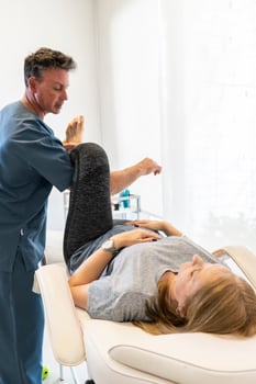 Physiotherapist working on woman's legs for wellness and disability support. Vertical shot photo