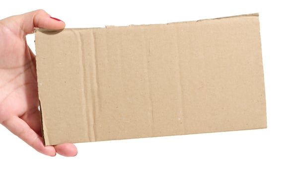 Female hand holding a piece of brown cardboard on isolated background, space for copy photo