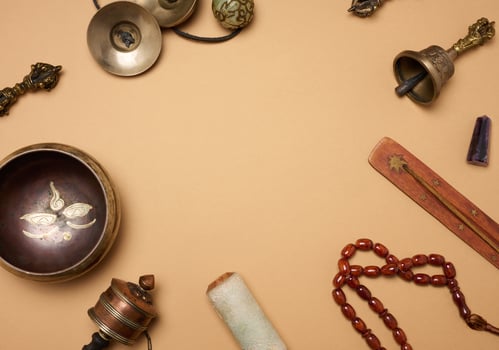 Tibetan singing copper bowl with a wooden clapper on a brown background, objects for meditation and alternative medicine. photo