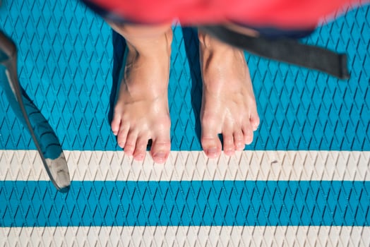 Crop barefoot person standing on SUP board photo