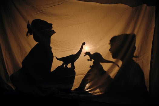 Mom and son playing with dinosaurs in shadow theater photo