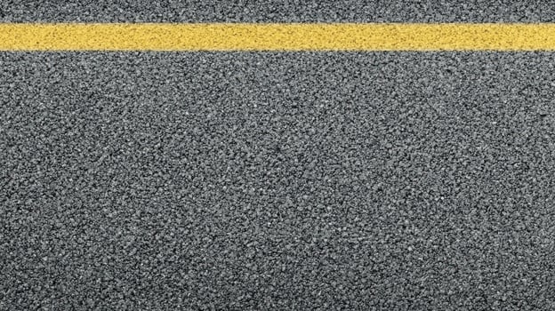 Close-up view of asphalt road surface with yellow line for transportation concept photo
