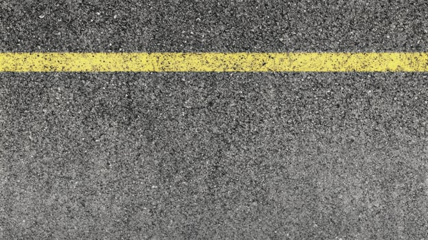 Close-up of asphalt road surface with yellow line for traffic guidance concept photo