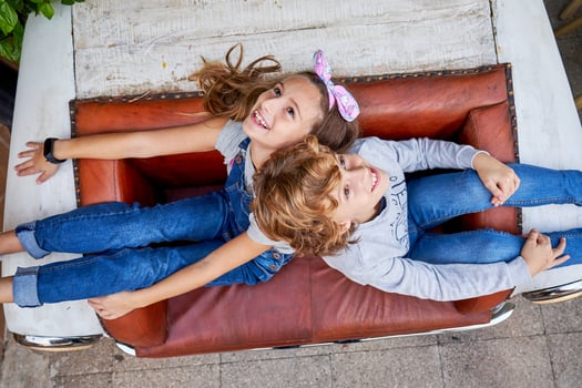 Cheerful children relaxing on vintage sofa on street photo