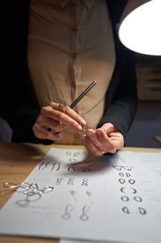 Crop goldsmith working at table under lamp photo