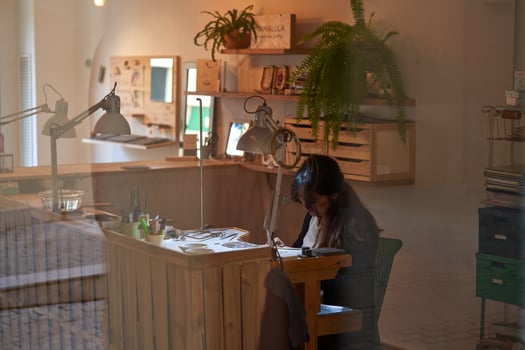 Professional female jeweler working at wooden bench photo