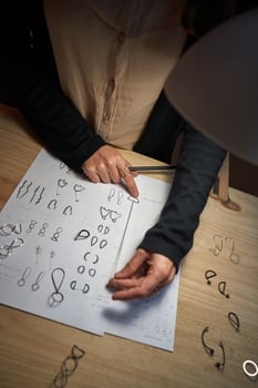 Faceless artisan with pendant drawing illustrations on paper photo