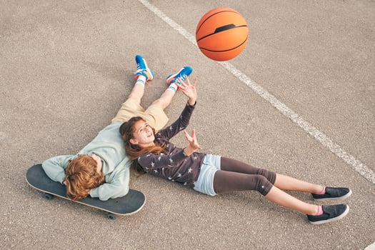 Cheerful teenage girl and boy lying on sports ground photo