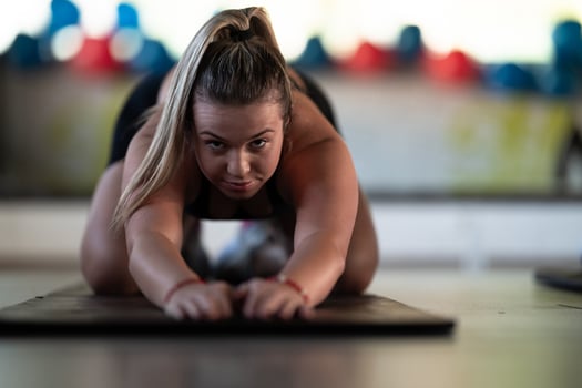 A woman stretches her body in the gym after an intense workout, a healthy muscle stretch after training. photo