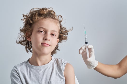 Calm kid with nurse showing syringe photo