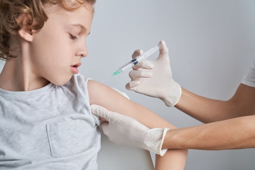Faceless nurse injecting kid with syringe photo