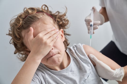Anonymous medic injecting scared child photo