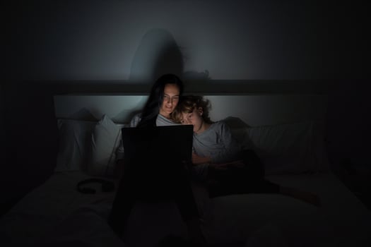 Mother with son doing homework in darkness photo