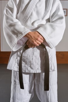 Crop man in kimono with crossed hands photo