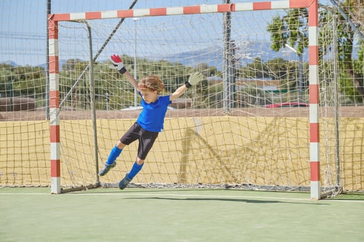 Boy catching ball at football goal photo