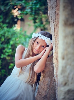 Young woman in bridal dress leaning on wall while looking at cam photo