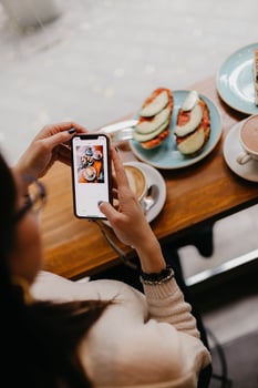 Woman taking a photo of food on a table