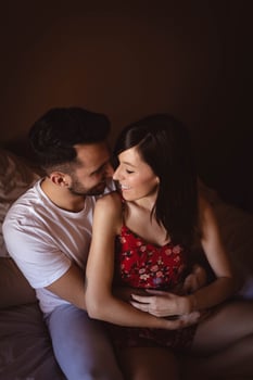 Happy couple sitting on bed photo