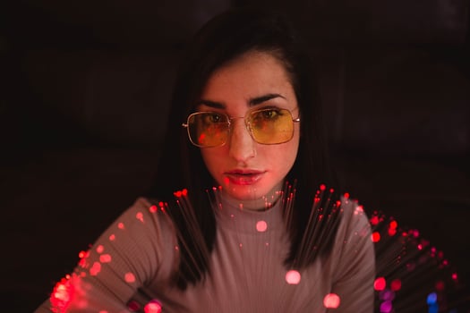 Young woman with fairy lights in darkness photo