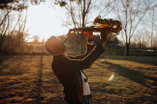 A man playing a saxophone in a park photo