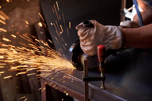 Crop man doing metalwork with angle grinder photo