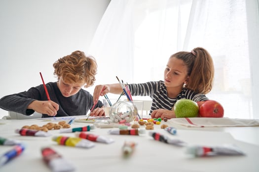 Children painting together at table photo