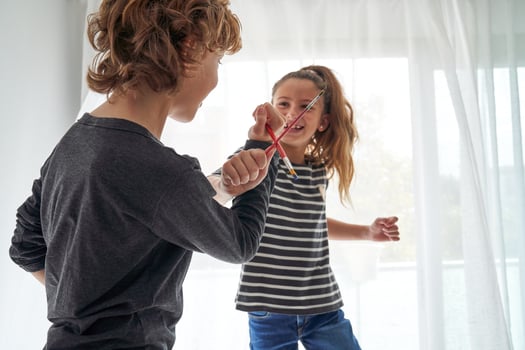 Boy and girl playing with paintbrushes photo