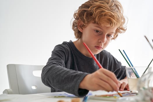 Cute boy painting with aquarelle photo