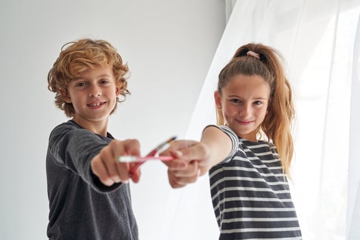 Cheerful children with paintbrushes in room photo