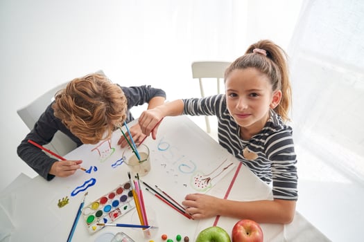 Positive girl painting near boy photo