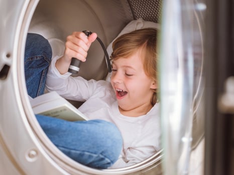 Amazed boy reading book in washing machine photo
