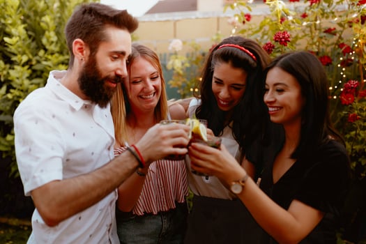 Group of cheerful friends clinking glasses at party photo