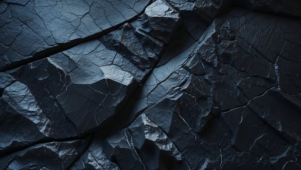 Dark rock face showing cracks and texture forming dramatic background photo