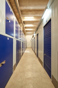 A long hallway with blue doors and storage units photo