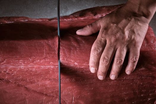 A person's hand is touching a piece of meat photo