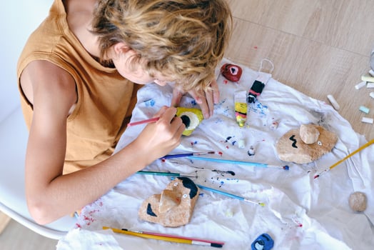 Child painting stone with aquarelle at home photo