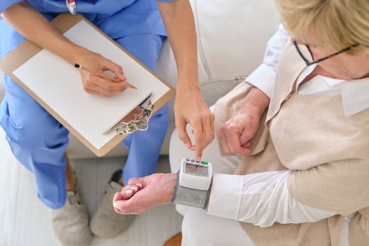 Crop physician measuring pulse rate of patient with tonometer photo