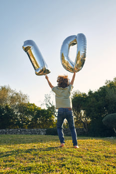 Unrecognizable boy with number balloons during birthday on meado photo