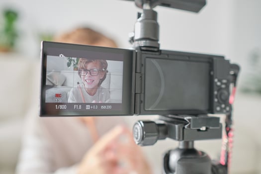 Boy recording on professional camera at daytime photo